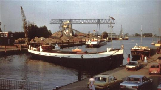 Ein Binnenschiff wendet im Hafenbecken. Dieses Bild dürfte den Autos nach zu urteilen aus den 60er- oder 70er-Jahren stammen.