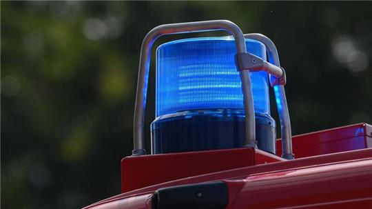 Ein Blaulicht leuchtet auf dem Dach eines Einsatzfahrzeugs der Feuerwehr.