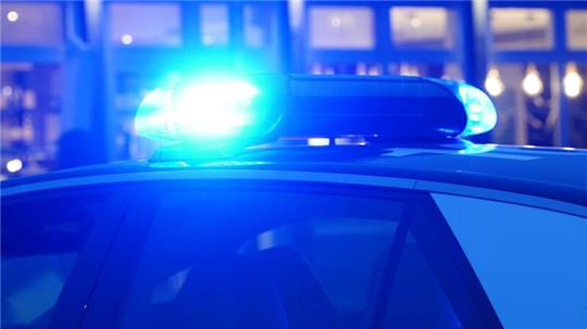 Ein Blaulicht leuchtet auf dem Dach eines Polizeiautos während einer Polizeiabsperrung.