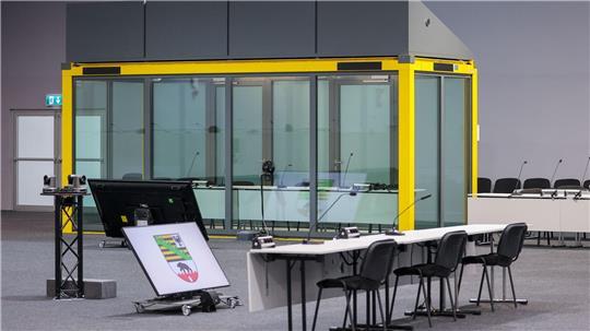 Ein Blick in den Gerichtssaal auf den Platz für die Zeugen und die Glaskabine, in der der Angeklagte während der Verhandlungen sitzt. (Archivbild) 