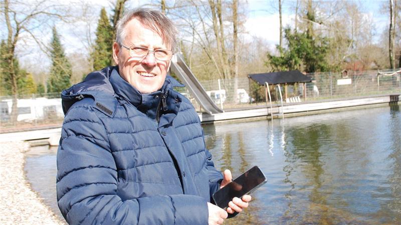 Ein Blick ins Handy zeigt Bernd Eschig die Energieeinspeisung durch die PV-Anlage, die am hinteren Rand des Naturbads installiert ist.