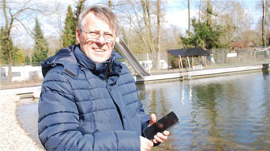 Ein Blick ins Handy zeigt Bernd Eschig die Energieeinspeisung durch die PV-Anlage, die am hinteren Rand des Naturbads installiert ist.