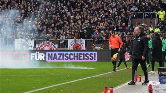 Ein Böller explodiert am Millerntor in der Nähe der Trainerbänke.