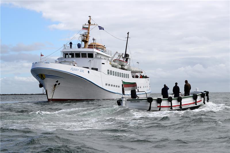 Ein Börteboot ist auf dem Weg zu dem Ausflugsschiff Funny Girl. Das erste Börteboot mit Elektromotor soll von Mitte Mai an vor Helgoland getestet werden. Foto Christian Charisius/dpa