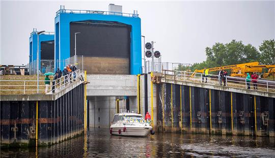 Ein Boot fährt aus der Hadelner Kanalschleuse. Das derzeit größte Küstenschutzprojekt Niedersachsens, der Neubau der Hadelner Kanalschleuse bei Otterndorf, wird nach vier Jahren Bauzeit in Betrieb genommen. Foto: Sina Schuldt/dpa