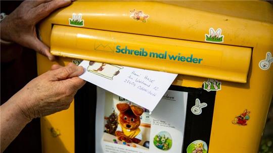 Ein Brief, den ein Kind für den Osterhasen Hanni Hase geschrieben hat, wird in einen Briefkasten geworfen.