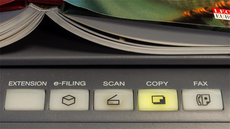 Ein Buch liegt auf einem Multifunktionsdrucker.