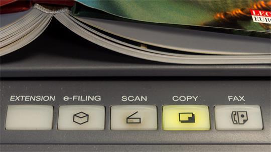 Ein Buch liegt auf einem Multifunktionsdrucker.