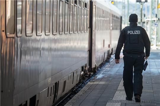 Ein Bundespolizist geht am Bahnhof neben einem Zug. Foto: picture alliance / dpa