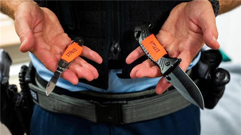 Ein Bundespolizist zeigt am Hauptbahnhof Hamburg sichergestellte Messer. (Archivbild)