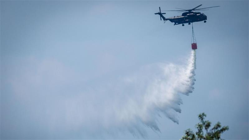 Ein Bundeswehr-Hubschrauber wirft Löschwasser über einem Waldbrand im Müritz-Nationalpark ab