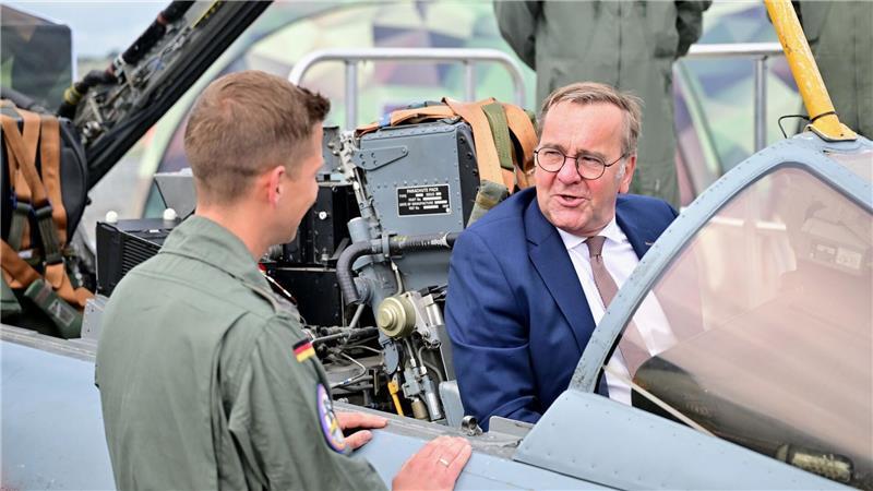 Pistorius: Entscheidung zu neuem Kampfjet steht noch aus Ein Bundeswehr-Soldat zeigt dem Minister auf der ILA einen Tornado-Simulator.