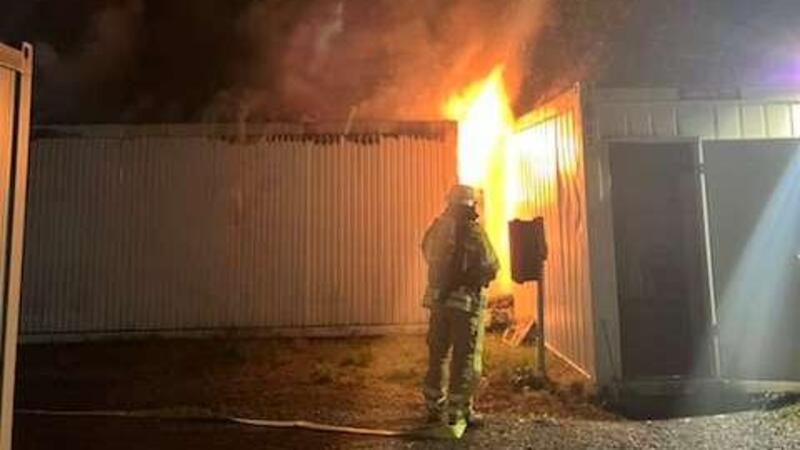 Feuer in Stader Flüchtlingsunterkunft - 30.000 Euro Schaden Ein Feuerwehrmann steht vor dem brennenden Container.