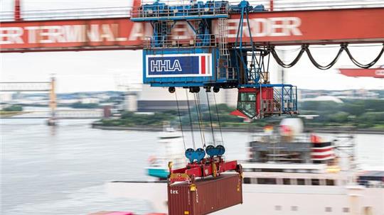 Ein Container wird auf dem Container-Terminal Altenwerder im Hamburger Hafen mit einer Containerbrücke auf ein Schiff geladen.