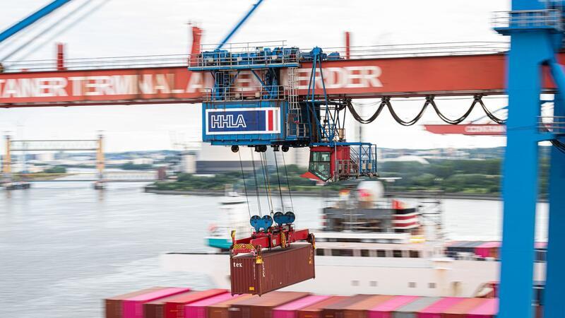 Konjunkturflaute lässt Gewinn bei HHLA einbrechen Ein Container wird mit einer Containerbrücke auf ein Schiff geladen.