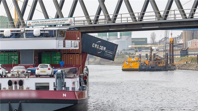 Ein Containerschiff liegt im Neusser Hafen. Das Schiff hat eine Brücke gerammt, mehrere Container fielen ins Wasser.