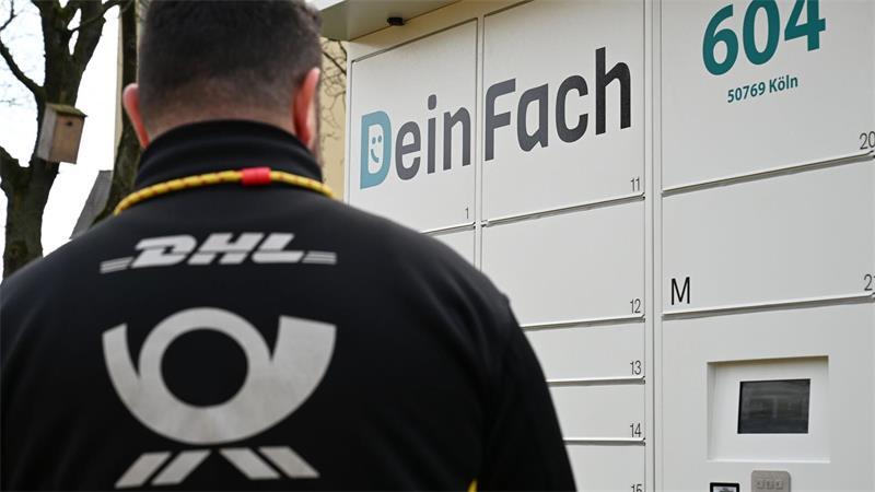 Post plant Zehntausende neue Paketautomaten - Firmenzukauf Ein DHL-Paketbote holt Sendungen aus einem DeinFach-Automaten.