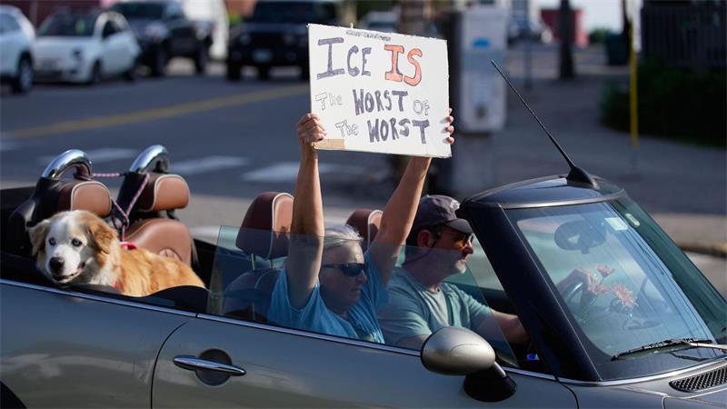 Ein Demonstrant hält ein Schild hoch.