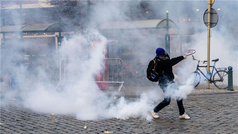 Ein Demonstrant schlägt bei den Protesten in Brüssel gegen einen Tränengasbehälter.  