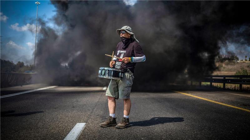 Bilder des Tages Ein Demonstrant trommelt bei einer Straßenblockade in Israel für die sofortige Freilassung aller von der Terrororganisation Hamas festgehaltenen Geiseln und das Ende des Krieges im Gazastreifen.