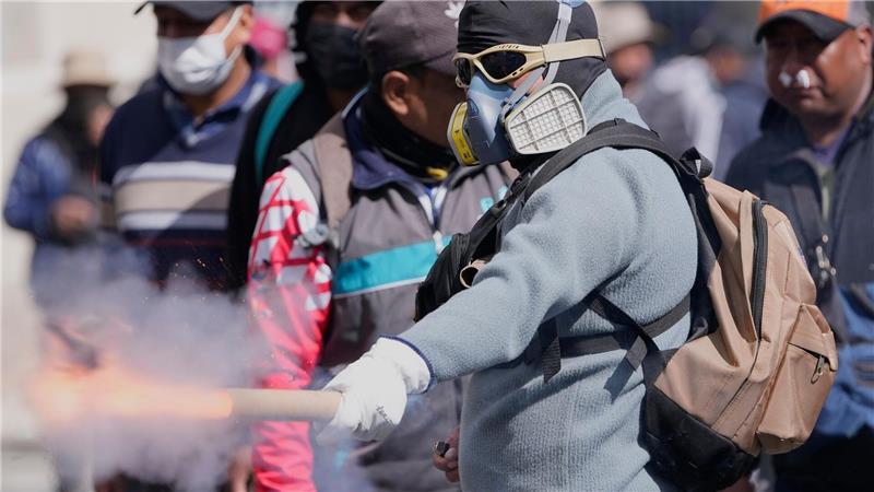 Ein Demonstrant wirft einen Feuerwerkskörper auf die Polizei.