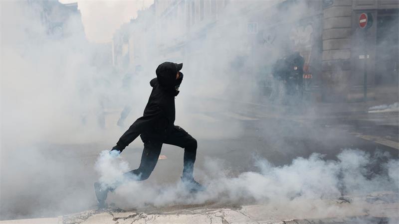 Ein Demonstrant wirft in Rennes eine Tränengasgranate in Richtung der Polizei.