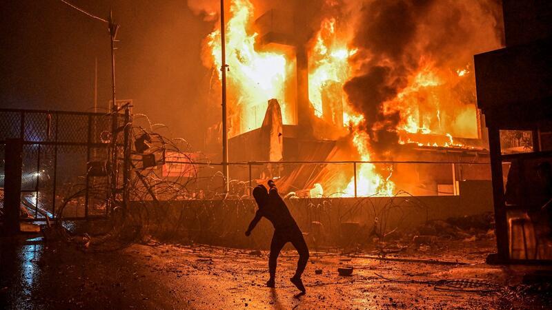 Wut in Nahost über Explosion bei Gaza-Klinik Ein Demonstrant wirft nach dem Angriff auf das Krankenhaus im Gazastreifen Steine auf ein brennendes Gebäude in der Nähe der US-Botschaft in Beirut.