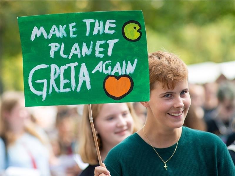 Ein Demonstrationsteilnehmer bei einer Klimademonstration „Fridays for Future“ hält ein Schild mit der Aufschrift „Make the Planet Greta again“ hoch. Foto: dpa
