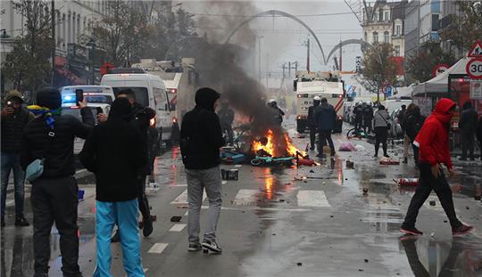 Ein E-Scooter liegt in einem Feuer auf einer Straße in der Brüsseler Innenstadt. Fußballfans haben nach Marokkos WM-Sieg randaliert. Foto: Nicolas Maeterlinck/BELGA/dpa