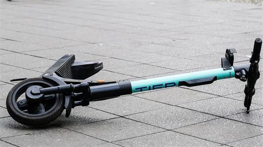 Ein E-Scooter liegt umgekippt mitten auf einem Gehweg. (zu dpa: «Deutlich mehr schwere E-Scooter-Unfälle - das sagen Experten»)