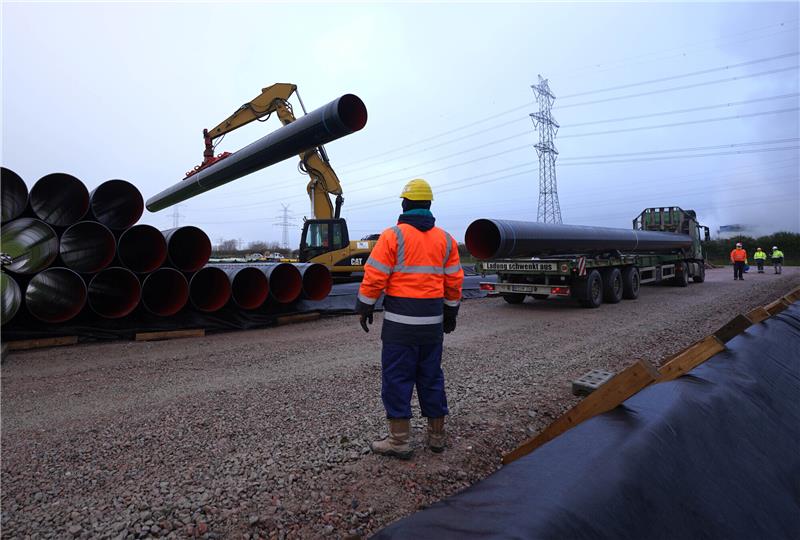 Ein ETL 180 Gasrohr wird auf dem Rohrlagerplatz von Gasunie Deutschland in Brunsbüttel abgesetzt. Die Rohre sind für die Verlegung der Gasleitung vom schwimmenden LNG-Terminal in Brunsbüttel nach Hetlingen im Kreis Pinneberg vorgesehen. Insgesamt 3000 Rohre sollen bis voraussichtlich Oktober 2023 auf 55 Kilometer Länge in der Erde verlegt werden. Foto: Marcus Brandt/dpa