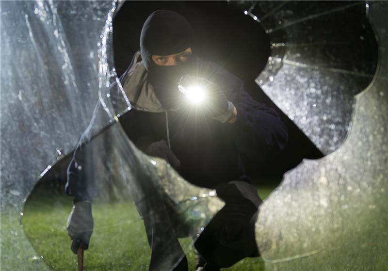Vier junge Männer brechen in Häuser in Bützfleth ein – Festnahme Ein „Einbrecher“ blickt an einem Haus durch eine eingeschlagene Fensterscheibe (gestellte Szene). Symbolfoto: Daniel Maurer/dpa