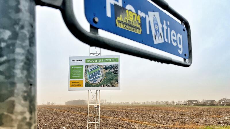 Neue Einfamilienhäuser in Stade doch noch möglich: Was hier in Bützfleth geplant ist Ein Einfamilienhaus mit Solarpaneelen auf dem Hausdach steht hinter einer grünen Hecke.