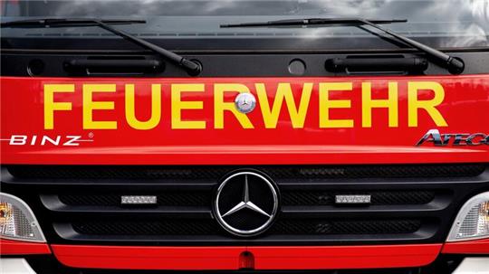 Ein Einsatzfahrzeug der Feuerwehr steht  auf einem Parkplatz.