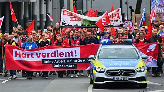Ein Einsatzfahrzeug der Polizei begleitet einen Demonstrationszug durch Bremen. 