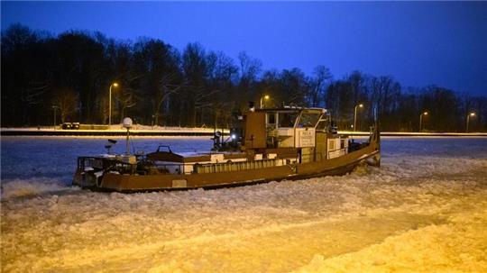 Ein Eisbrecher dreht am frühen Morgen auf dem vereisten Mittellandkanal vor der Schleuse Anderten Runden.