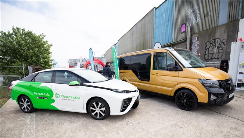 Ein Elektro-Sammeltaxi der VW-Tochter Moia und ein Fahrzeug von Clever Shuttle (links) stehen in der Hamburger Hafencity. Archivfoto: Christian Charisius/dpa