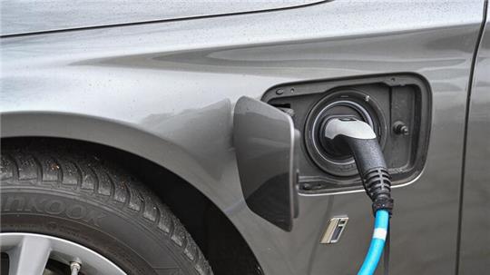 Ein Elektrofahrzeug der Marke BMW wird an einer Ladesäule aufgeladen.