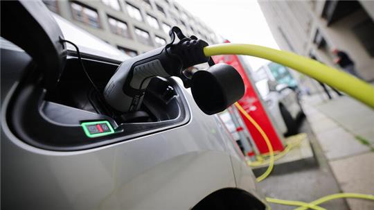 Ein Elektrofahrzeug wird an einer Ladesäule in der Innenstadt geladen.