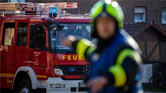 Ein Fahrzeug der Feuerwehr fährt an dem Einsatzort vor und wird vom Wehrführer eingewiesen (Symbolbild).
