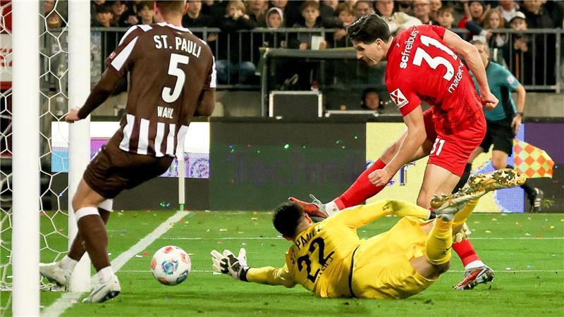 Ein Fehler mit Folgen: Freiburgs Igor Matanovic (r) nutzt den Patzer von St. Paulis Torwart Nikola Vasilj (M.) 