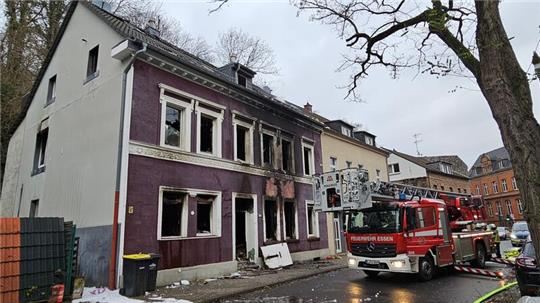 Ein Feuerwehrauto steht nach der Explosion in einem Mehrfamilienhaus vor dem zerstörten Gebäude.
