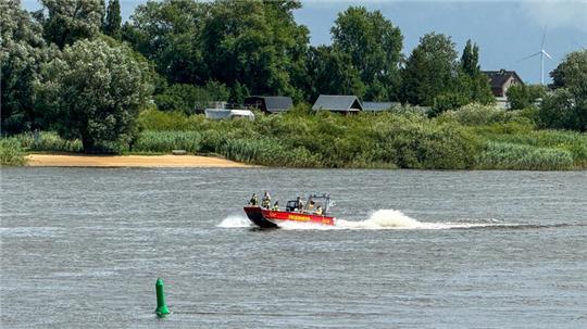 Ein Feuerwehrboot fährt während eines Einsatzes auf der Elbe 