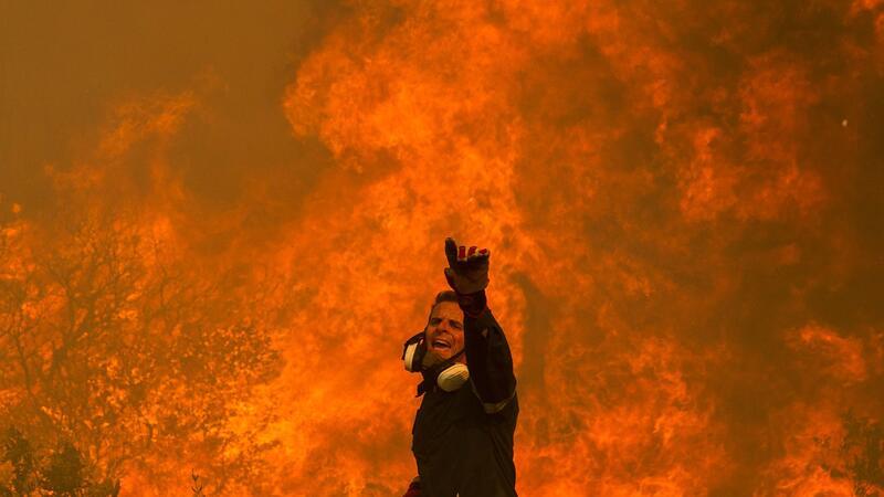Ein Feuerwehrmann kämpft in einem Dorf in der Nähe von Athen gegen einen Waldbrand.