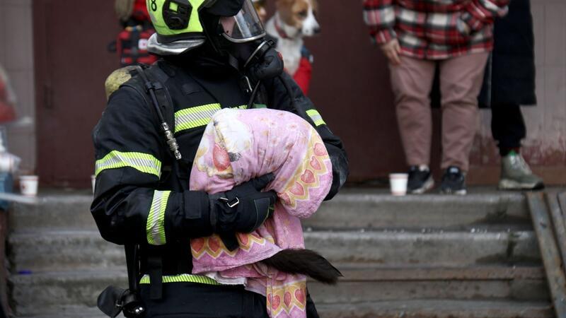 Ein Feuerwehrmann rettet in Kiew ein Tier nach einem russischen Angriff.