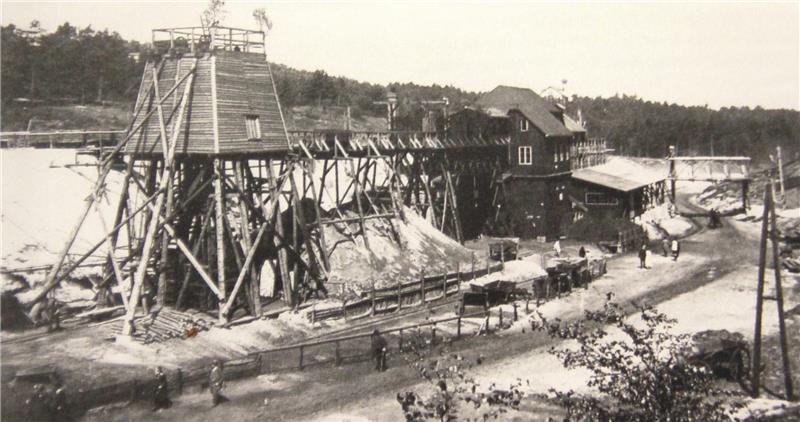 Ein Foto aus der Betriebszeit von Robertshall zeigt das überwiegend aus heimischem Holz gebaute Bergwerk am Ehestorfer Heuweg. Vom Förderturm gingen die Loren mit den mit Sand vermischten Kohleklumpen in die Kohlenwäscherei (rechts), von do