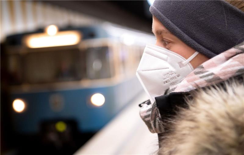 Ein Frau mit FFP2-Maske wartet auf die Bahn.