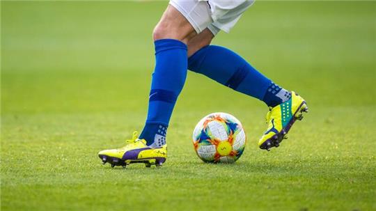 Ein Fußballspieler spielt den Ball.