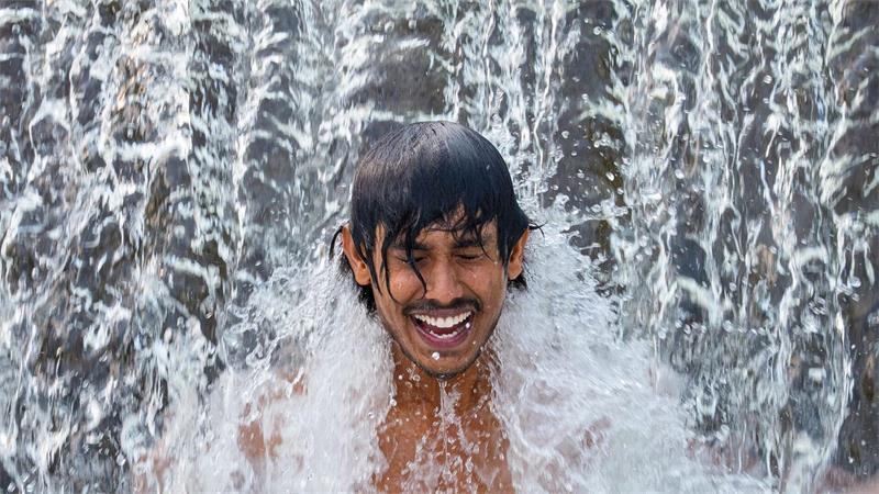 Ein Gastarbeiter aus Sri Lanka kühlt sich an einem glühend heißen Tag in einer Wasserkaskade eines Flusses außerhalb der Stadt Bragadiru in Rumänien ab.