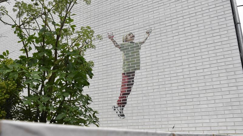 Ein Gedenkgarten soll an die getöteten Kinder erinnern. An einer Hauswand: Ein Kind, das einen Drachen steigen lässt.